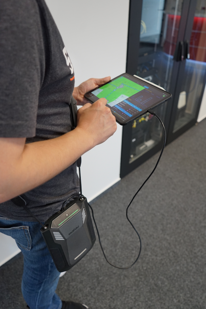 Person, die mithilfe eines Ekahau Sidekick und eines Tablets eine WLAN-Standortanalyse durchführt