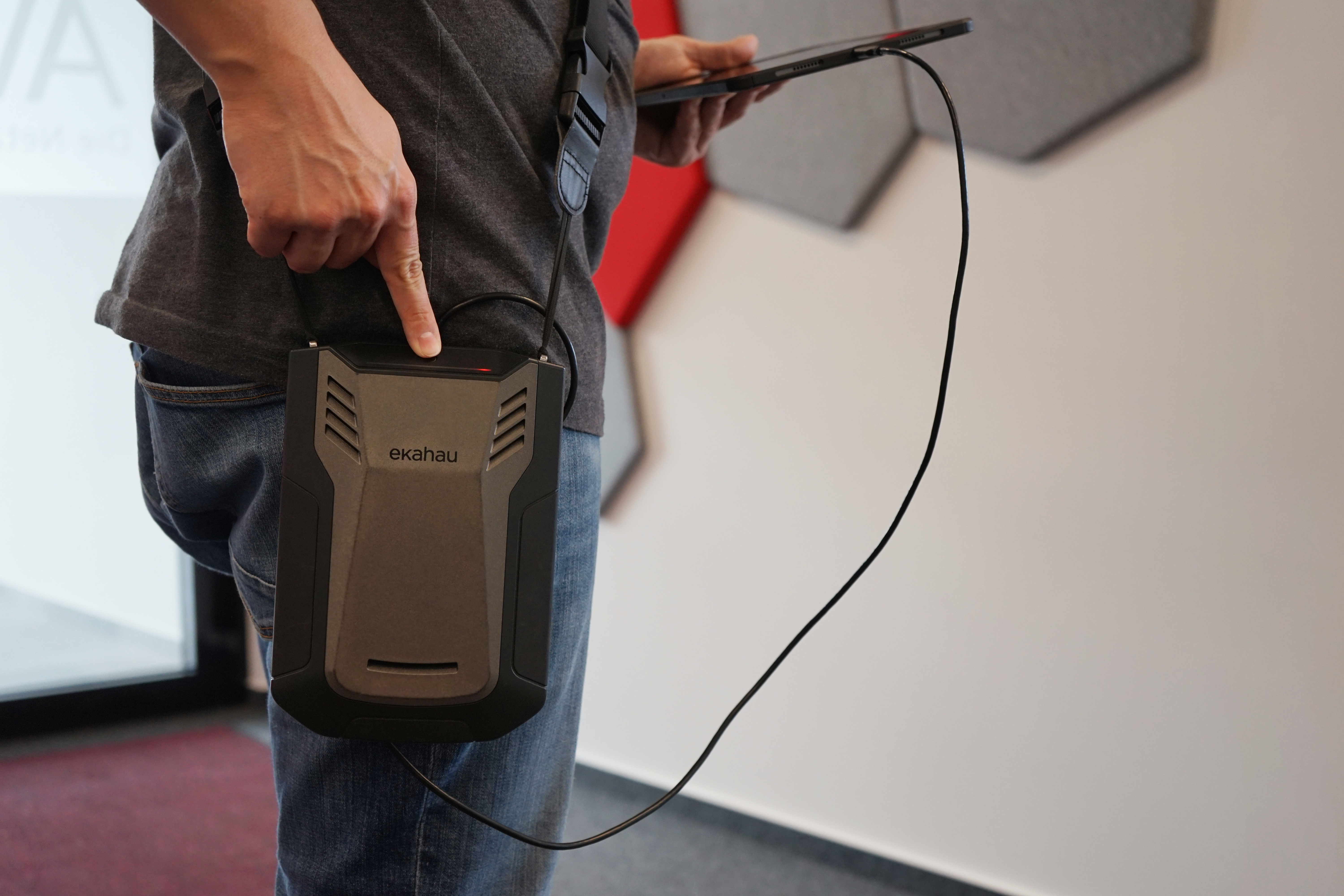 Person, die mithilfe eines Ekahau Sidekick und eines Tablets eine WLAN-Standortanalyse durchführt
